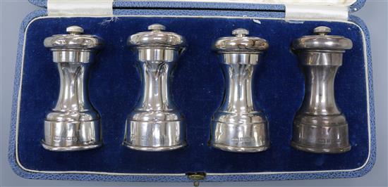 A cased set of four George V silver capstan shaped pepper mills, Hukin & Heath Ltd, Birmingham 1913, 91mm.
